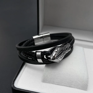 Macro detail of hand-woven leather bracelet featuring a silver polished snake head