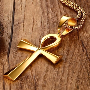 Polished gold Ankh cross pendant necklace made of stainless steel on wooden background