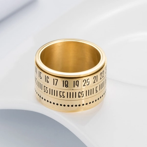 Detail of golden stainless steel ring with rotating Arabic numerals and calendar scale