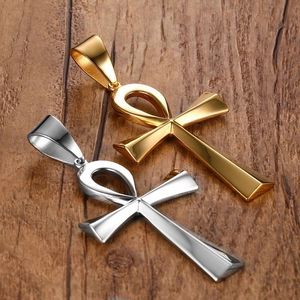 Polished stainless steel Ankh cross pendants in gold and silver on a wood background