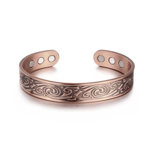 Macro detail of retro copper magnetic therapy bracelet with scroll engraving