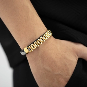 Close-up of men's leather and gold titanium steel watch-style link bracelet on wrist
