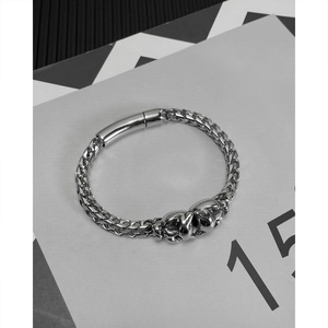Detail of silver titanium wheat chain bracelet with hip hop tiger head charm and polished clasp