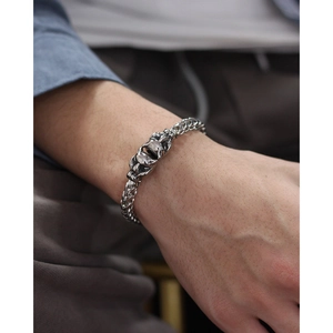Close-up of a punk-style double tiger head wheat chain bracelet for men in stainless steel