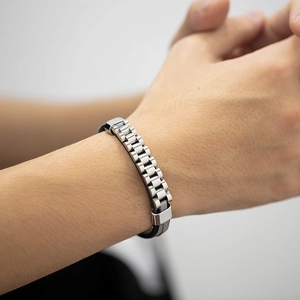 Detail of men's titanium steel and black leather strap bracelet with metallic clasp