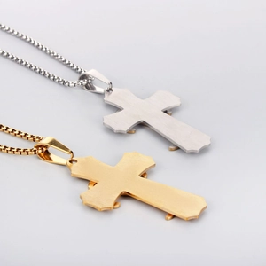 Detail of gold and silver cross pendants with brushed texture and square box chains