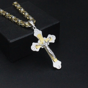 Detailed macro of gold and silver Byzantine chain with a triple-layered cross pendant