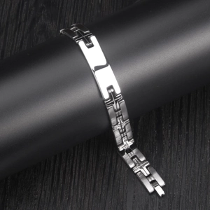 Polished stainless steel men's bracelet with brushed cross motifs on dark display