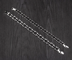 Lot de deux bracelets chaîne de moto en acier inoxydable bicolore sur fond bois