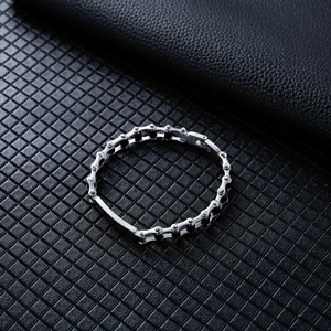 Macro detail of silver industrial stainless steel motorcycle chain bracelet on leather