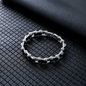 Men's stainless steel bracelet with industrial bicycle chain design on black leather background