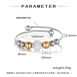 Detail of twisted steel cuff bracelet with gold beads and sparkling zircon inlay