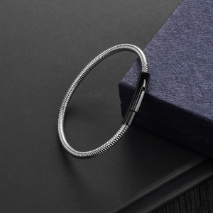 Silver snake bone chain bracelet with black clasp detail on a navy textured gift box
