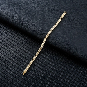 Detail of golden butterfly magnetic therapy bracelet with leaf texture on black leather