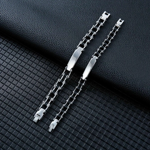Detail view of steel bicycle chain bracelet with polished ID plate on black leather