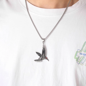 Détail du collier pendentif colibri avec œil en gemme rouge et finition argent vieilli