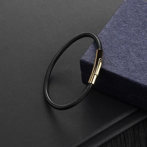 Macro view of minimalist snake chain bracelet with polished gold metal clasp detail