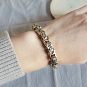 Macro shot of two-tone Byzantine chain bracelet in gold and silver stainless steel