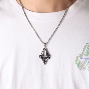 Retro Eye of Horus steel pendant on model with silver-tone curb chain and white tee