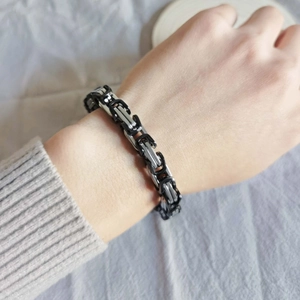 Macro detail of men's Byzantine chain bracelet in square woven stainless steel design