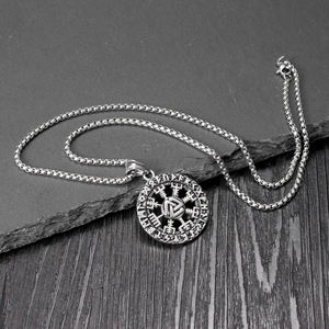 Vintage stainless steel Viking Rune pendant necklace on rustic stone background