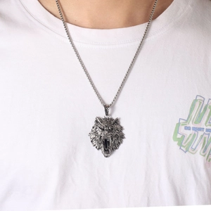 Detailed close-up of a punk wolf head pendant with square chain on a male model