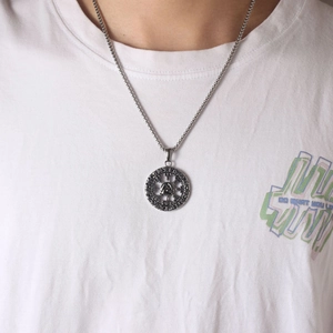 Macro shot of silver Valknut pendant with Norse runes on a stainless steel bead chain