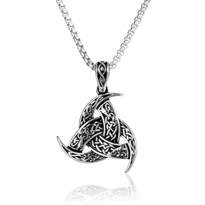 Macro detail of vintage Triple Horn of Odin pendant with intricate Celtic knot patterns