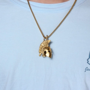 Detail of vintage gold Spartan helmet pendant showing intricate textures and square chain link