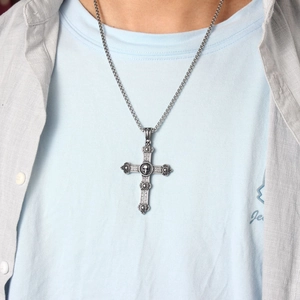 Gothic silver cross pendant necklace with skull center worn by male model on box chain