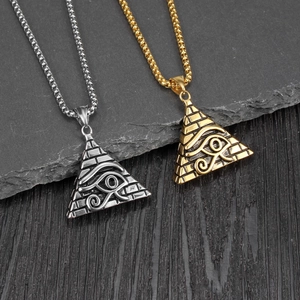 Close-up of gold and silver pyramid pendants with Eye of Horus relief on stone