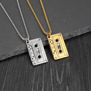 Close-up of retro cassette tape pendants in gold and silver finish with ball chain necklaces