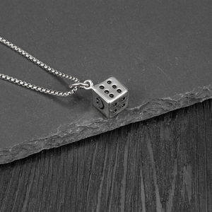 Macro del ciondolo a dado industriale con faccina su una catena box argentata