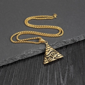 Macro shot of Egyptian pyramid pendant with Eye of Horus on rustic stone surface