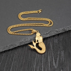 Fashionable gold mermaid pendant necklace with detailed scales on a grey rock background