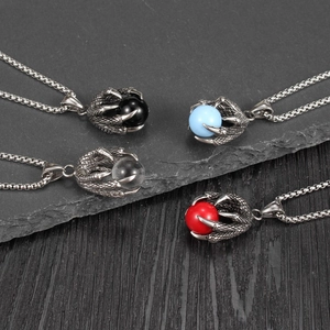 Détail de pendentifs griffe de dragon avec pierres précieuses sur fond de pierre rustique