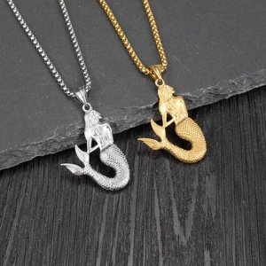 Detailed view of gold and silver mermaid pendants with scale texture on stone background