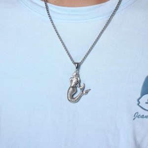 Close-up of silver mermaid pendant with detailed scales on a fine square link chain
