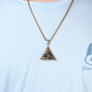 Detail of Eye of Horus pyramid pendant necklace on a blue shirt for vintage styling