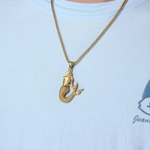 Detailed view of a golden mermaid pendant with intricate scale texture on a box chain