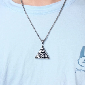 Macro detail of ancient Egyptian Horus Eye pyramid pendant on vintage silver chain