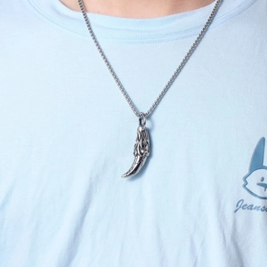 Close-up of vintage wolf tooth pendant with flame pattern on a stainless steel chain