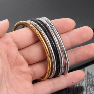 Unisex stainless steel spring serpent bracelets in gold, black, and silver metallic tones
