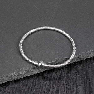 Detailed macro view of silver snake chain bracelet with a polished metal sphere bead