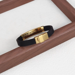 Detailed close-up of the engraved stainless steel mark on a gold silicone bracelet