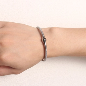 Detail of silver stainless steel snake chain bracelet with magnetic ball clasp on wrist