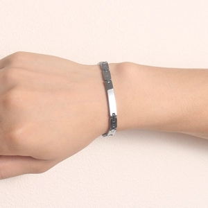 Gros plan d'un bracelet gourmette en acier inoxydable argenté avec plaque polie