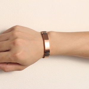 Close-up of rose gold mesh bracelet with a polished rectangular bar on model's wrist