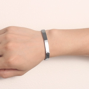Close-up of a silver stainless steel bar bracelet with industrial links on a wrist