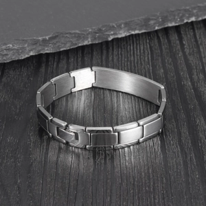 Vue détaillée d'un bracelet à maillons en acier argenté avec une plaque rectangulaire